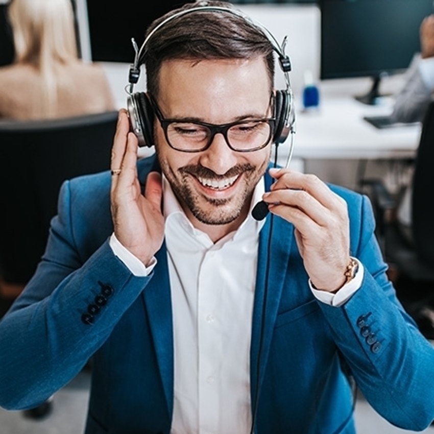Handsome male customer service agent working in call centre office as a telemarketer.
